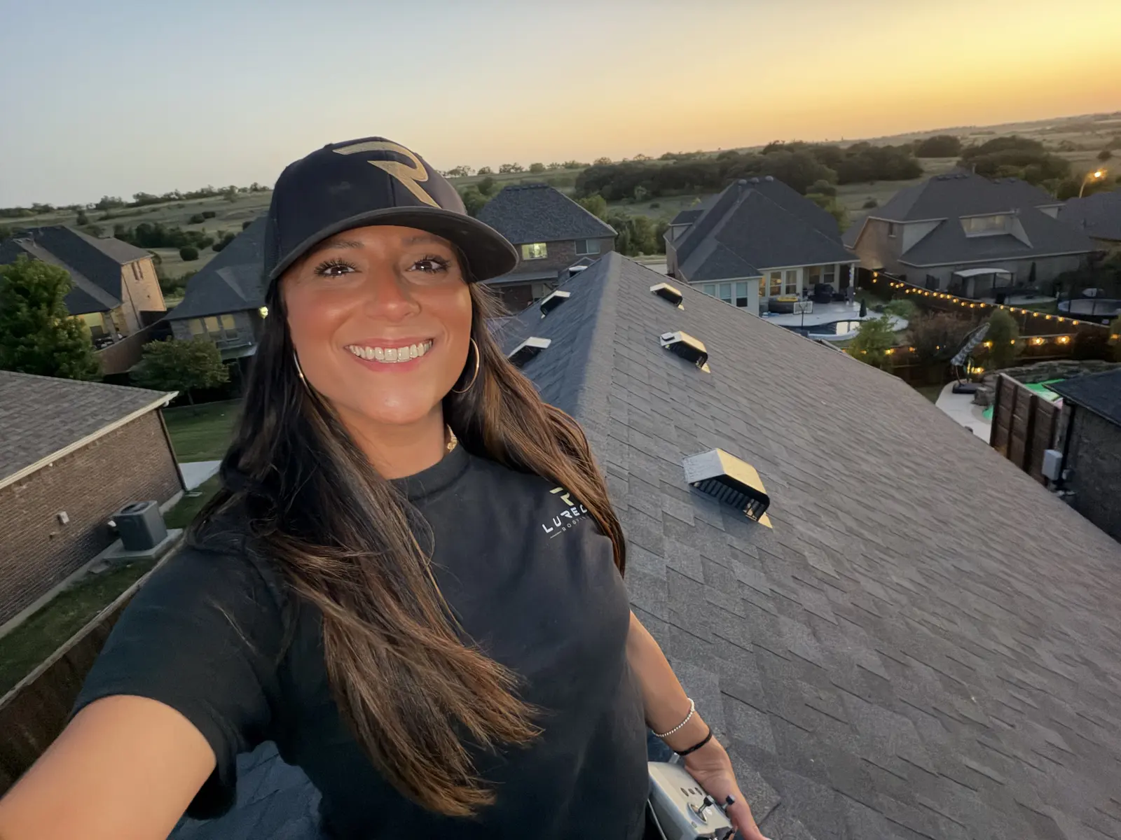 Lori Zertuche on a shingle roof at sunset